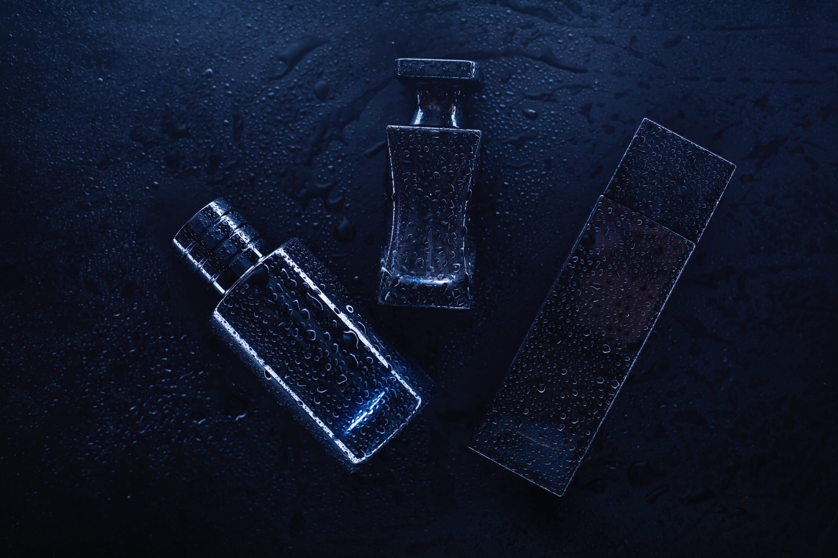 Three different perfumes on a dark background